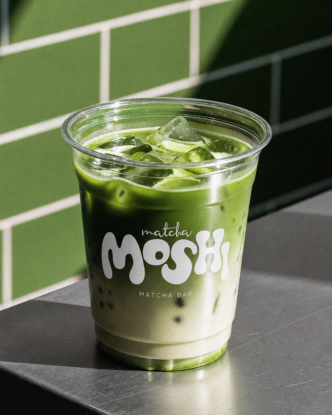 Vaso de MOSHI MATCHA en ambiente claro con muro verde